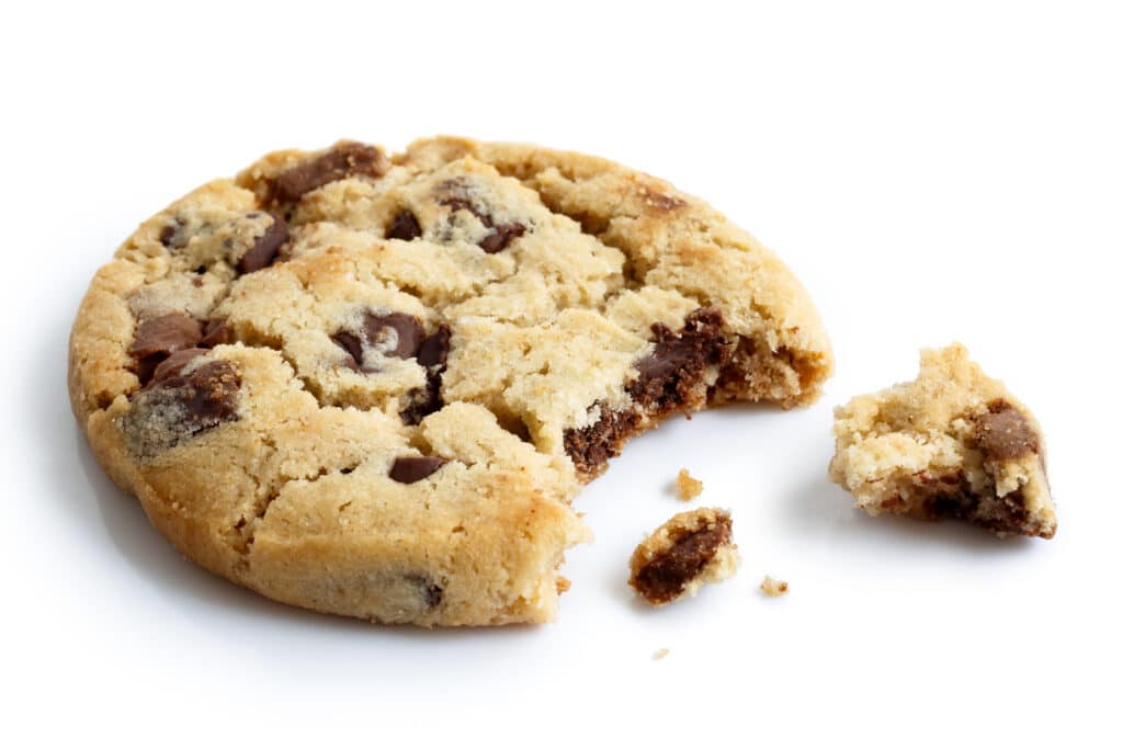 Single light chocolate chip cookie bite missing with crumbs isolated