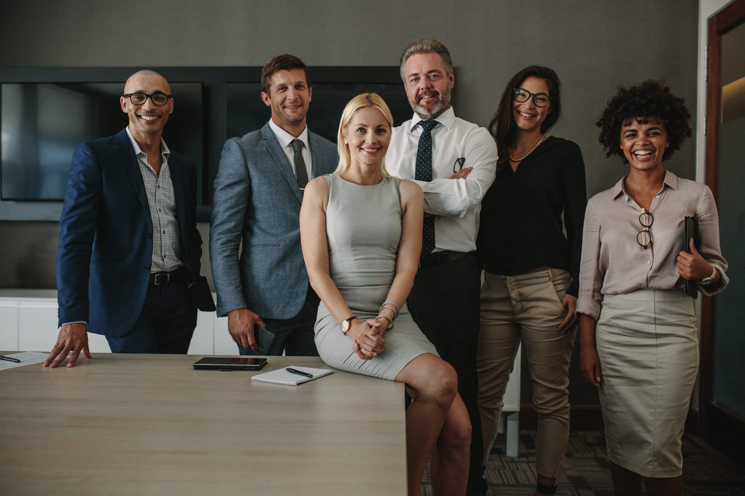 A diverse team of professionals from Blueprint Finance confidently posing in a modern office setting, radiating teamwork and expertise.